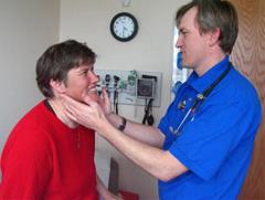 Doctor giving a patient a physical exam for preventative health screening.