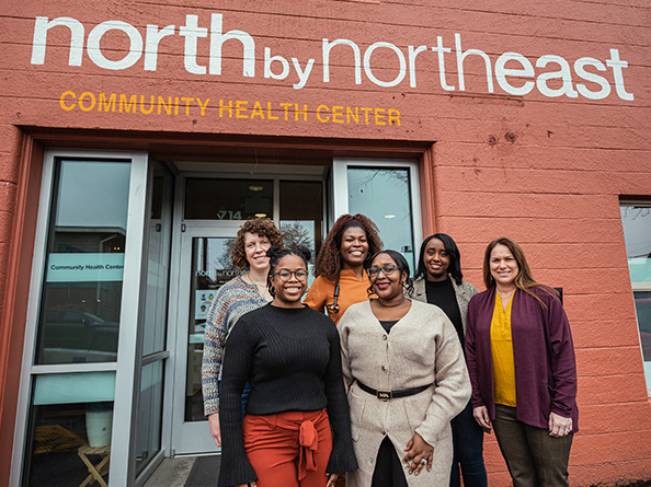 Voluntarios parados delante del North by Northeast Community Health Center