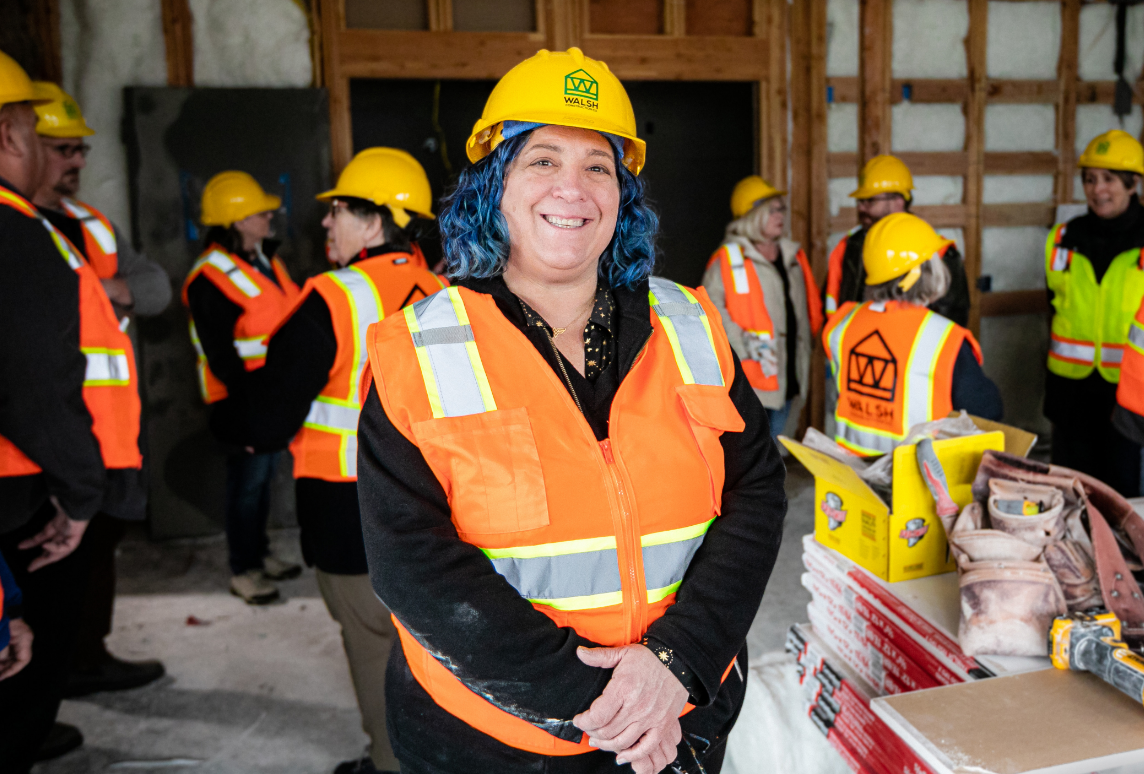 Elissa Gertler, executive director of Northwest Oregon Housing Authority, wears a yellow hardhat and orange vest while on a worksite tour of Trillium House at Chelsea Gardens.