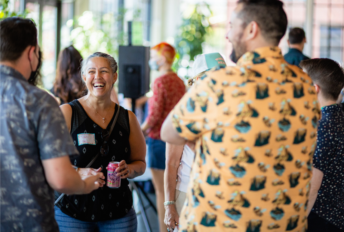 CareOregon employees, wearing casual summer clothes, laugh and talk with each other at the All Staff party held in August.