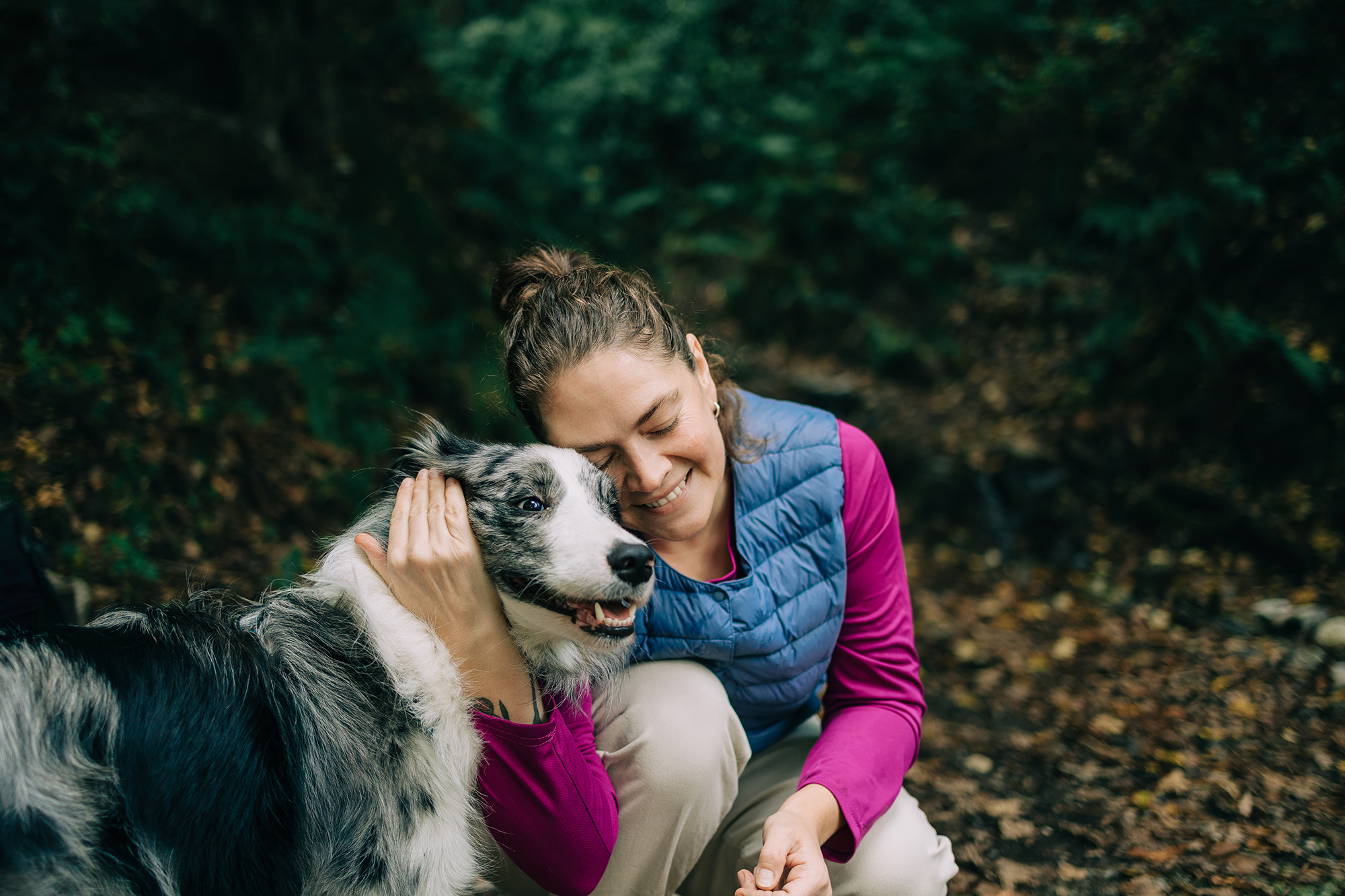 Woman outside with arm wrapped around dog