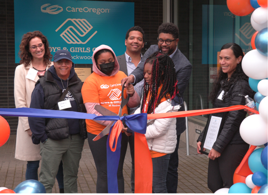 Un grupo de personas participan de la ceremonia de corte de cinta afuera del CareOregon Boys & Girls Club en Rockwood.