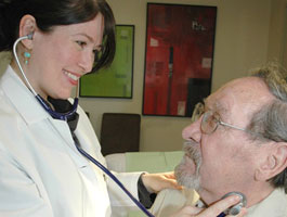 Enfermera escuchando los latidos de un paciente con un estetoscopio.