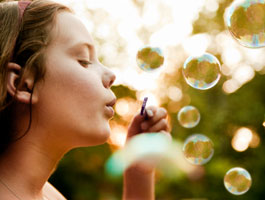 A kid blowing bubbles.