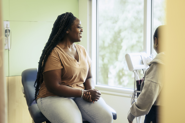 Smiling woman in the doctor’s office with doctor.