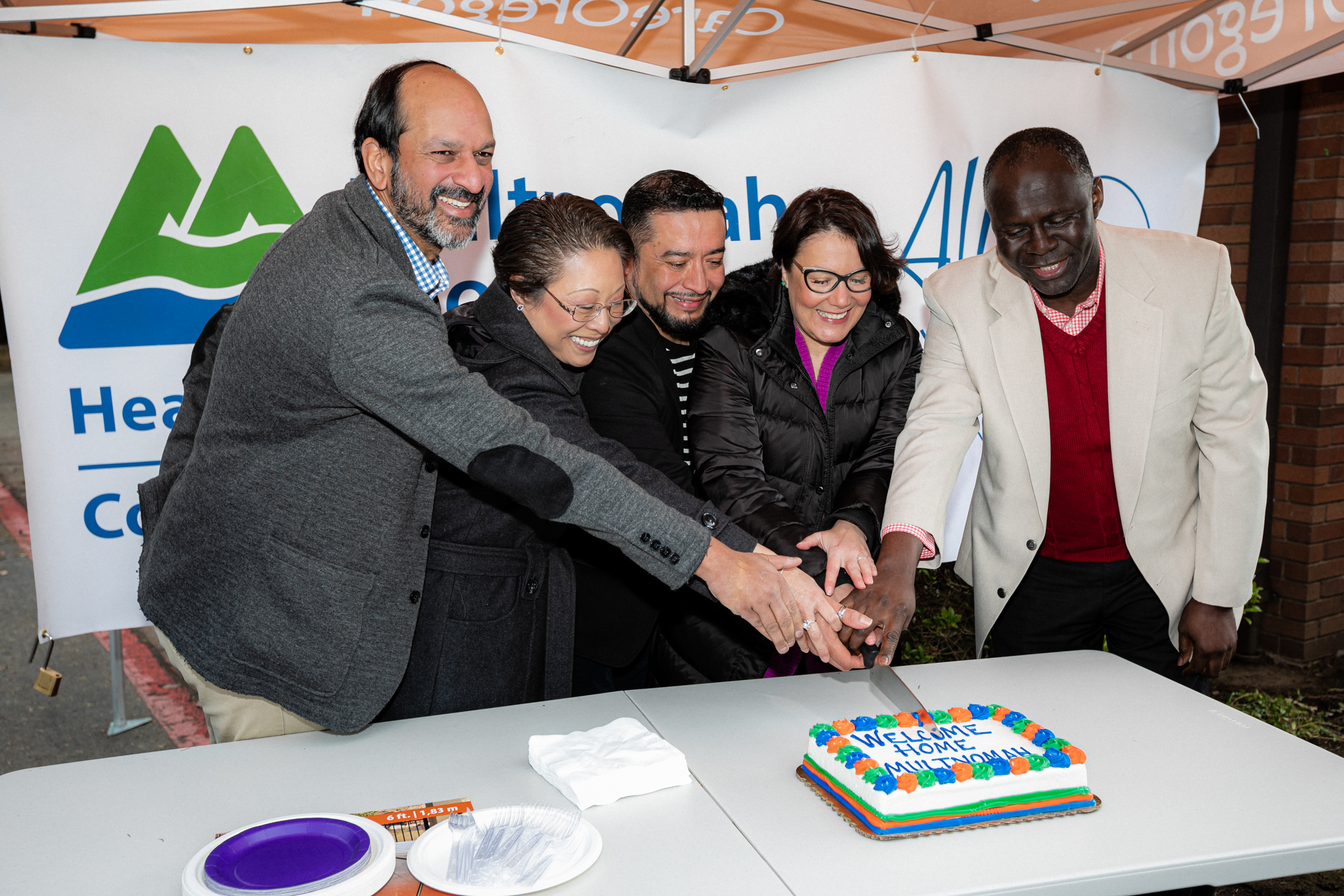 A group of people cutting a cake.