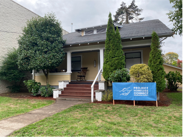 Small house with Blue banner in front yard that reads 