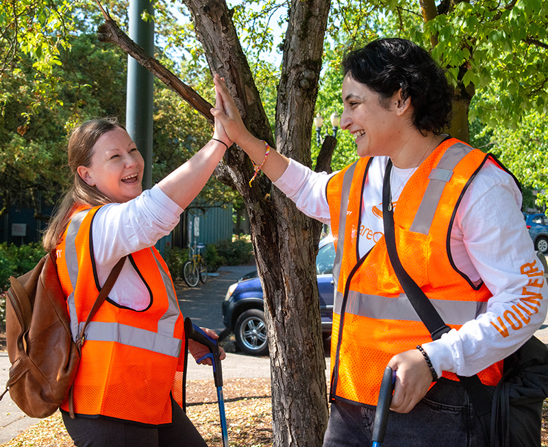 Dos miembros del equipo de CareOregon chocan sus manos