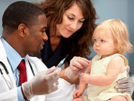 Doctor and nurse giving a baby a shot