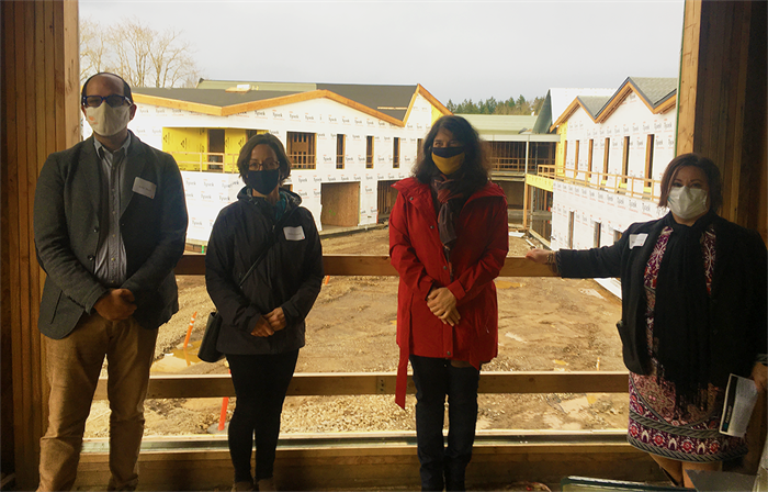 4 local leaders standing in front of a construction site